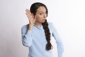 Woman Listening With Hand on Ear